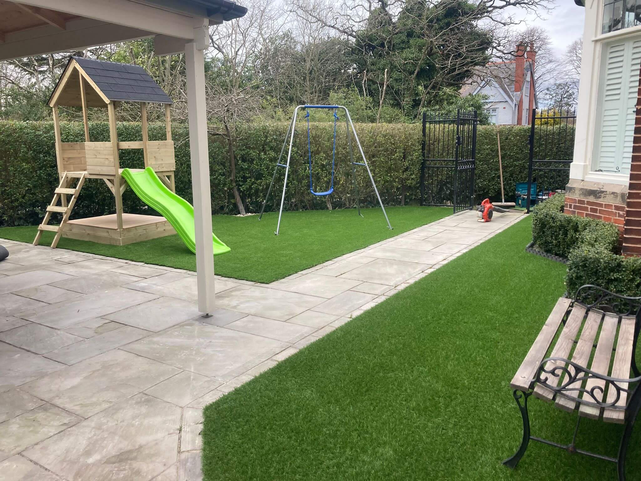 Photo of a garden with artificial grass and kids play equipment