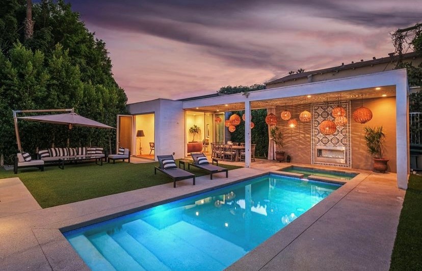 Photo of a Selling Sunset garden with hanging laight and underwater lighted pool.