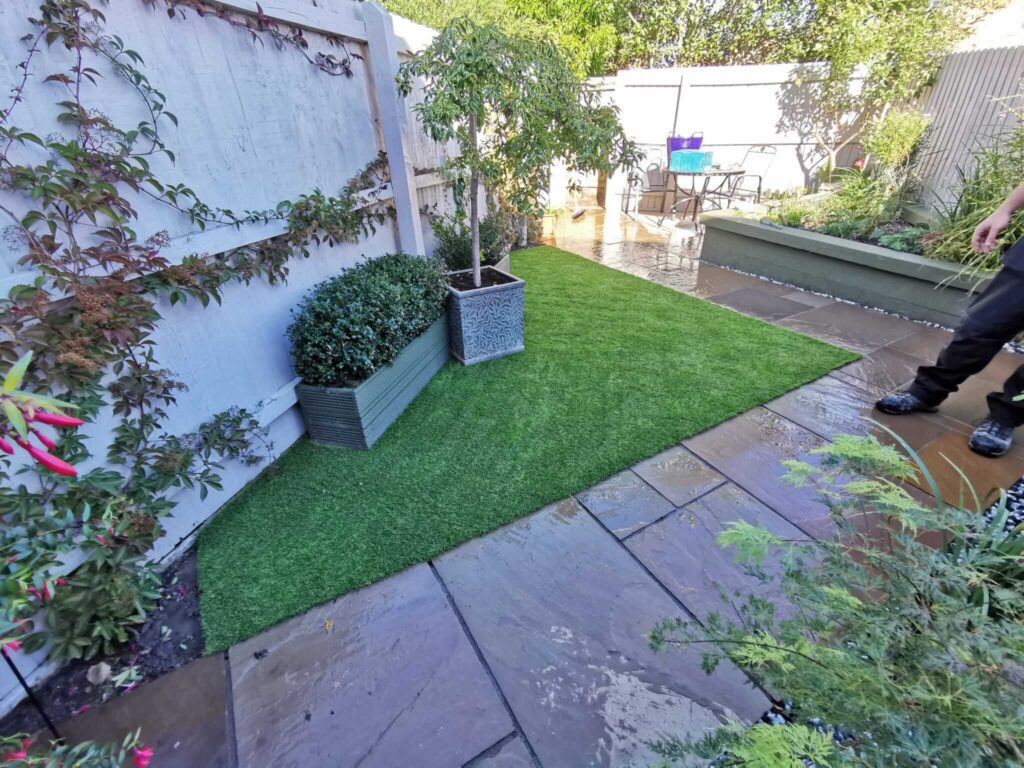 Photo of a small triangle artificial grass garden. 