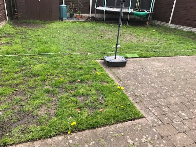 Photo of a back garden where the grass has disappeared and the garden has become a muddy mess. 