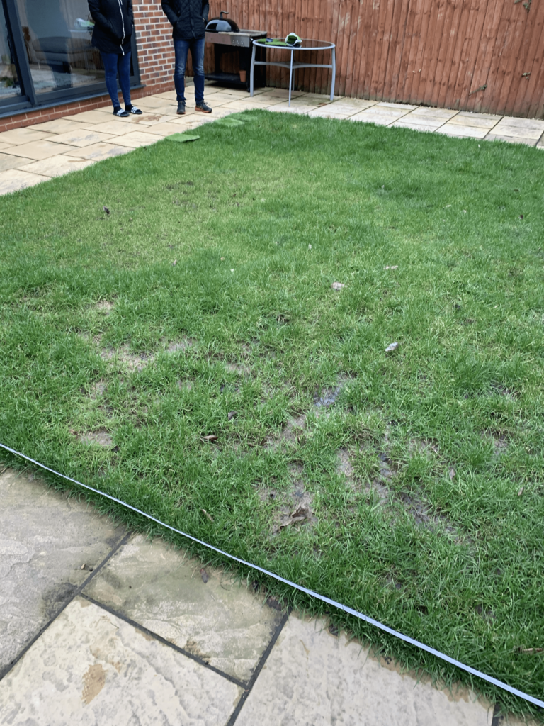 Photo of the garden before with missing grass and muddy patches.