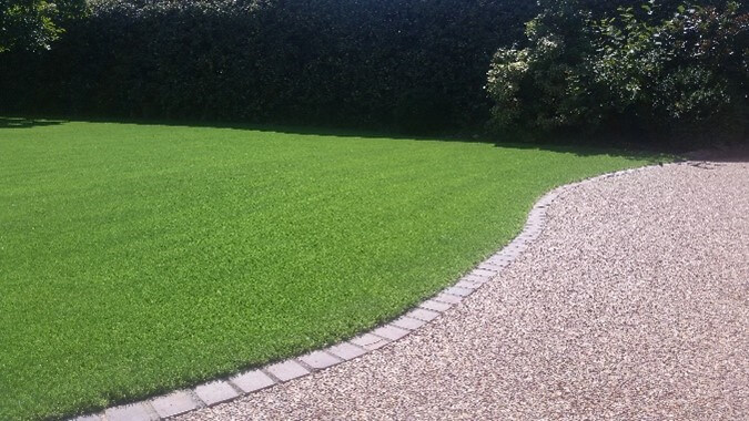 Photo of a garden with artificial grass installed as a grass alternative for kids.