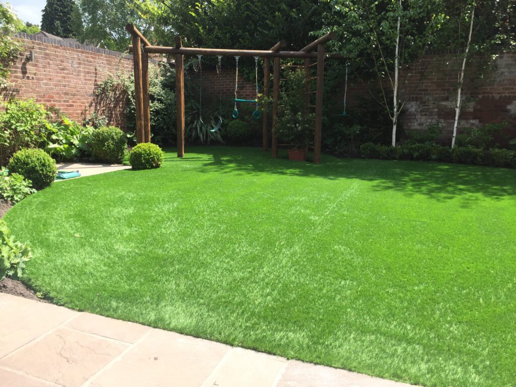 Photo of the garden finished with artificial grass around the climbing frame. 