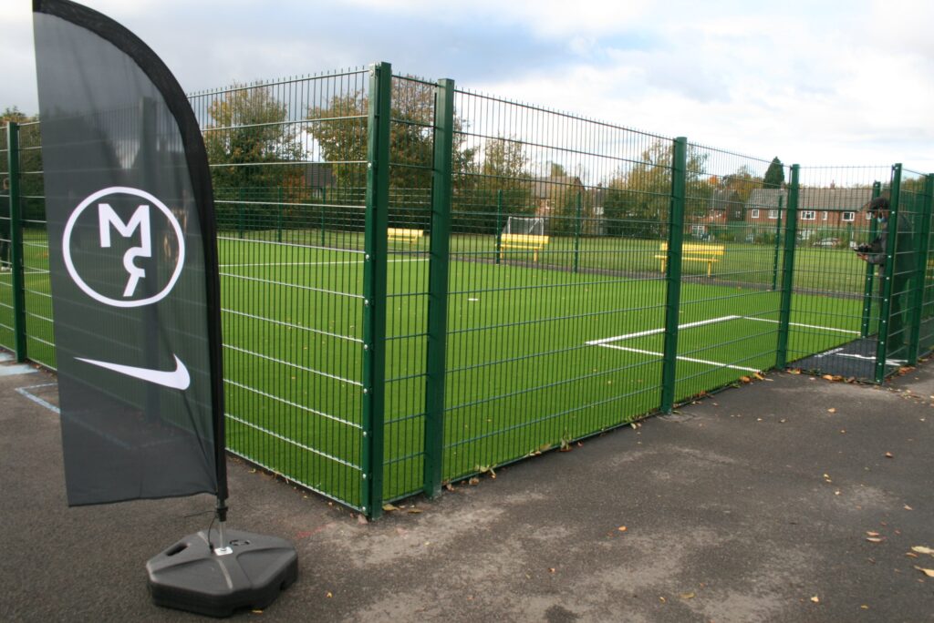 Photo of an artificial grass football pitch installed on the tarmac in a primary school.