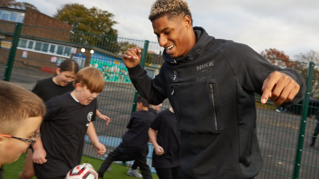 Photo of Marcus Rashford having a kickabout with the pupils at Button Lane Primary.
