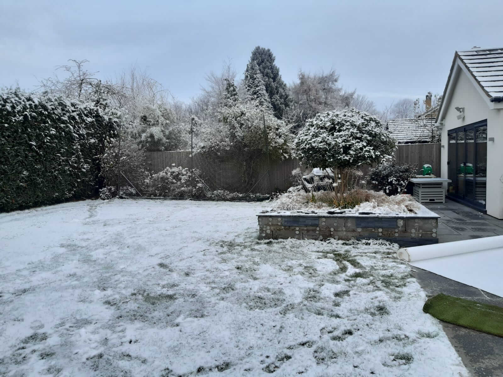 Photo of a muddy garden in winter covered with snow.
